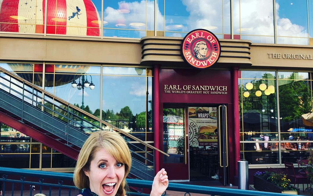 Woman posing in front of a restaurant called Earl Of Sandwich